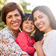 Grandmother, mother, and daughter smiling brightly