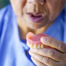 Man holding dentures in Montgomery