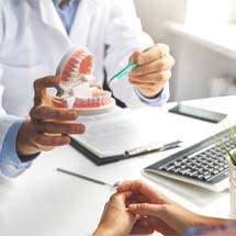 Dentist explaining cost of dentures in Montgomery to patient