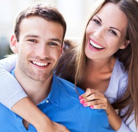 A couple smiling after cosmetic dental bonding