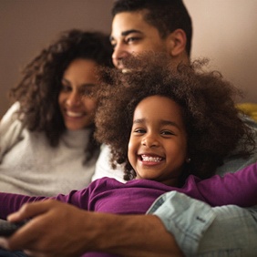 Parents and child laughing after visiting their family dentist