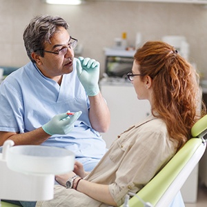 Dentist talking to female patient in dental chair