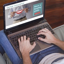 Man looking at dental insurance on lap top computer