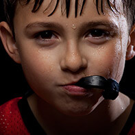 Boy biting into a sportsguard