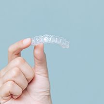 Patient holding Invisalign clear aligner