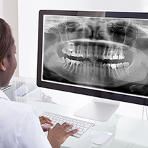 Dentist pulling up x-ray on computer