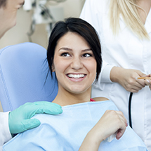 Lady on dental chair smiling at dentist
