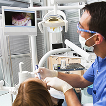 Dentist using intraoral camera to see inside patient’s mouth