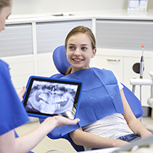 Dentist examining x-ray with smiling patient