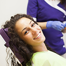 Young woman with curly hair smiling after wisdom tooth extraction