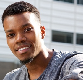 Man smiling outside after tooth colored filling restoration